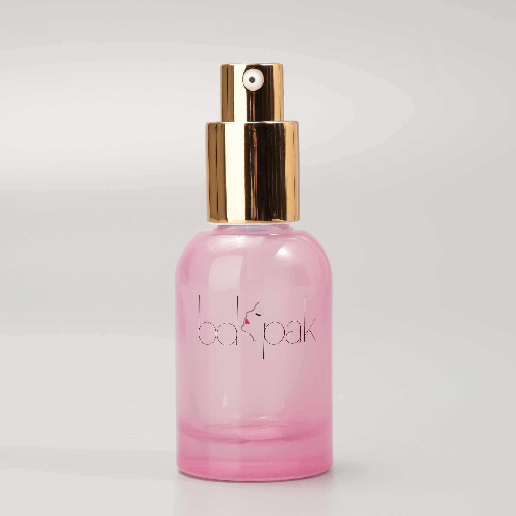 Rounded glass pump bottle with gold pump and cap